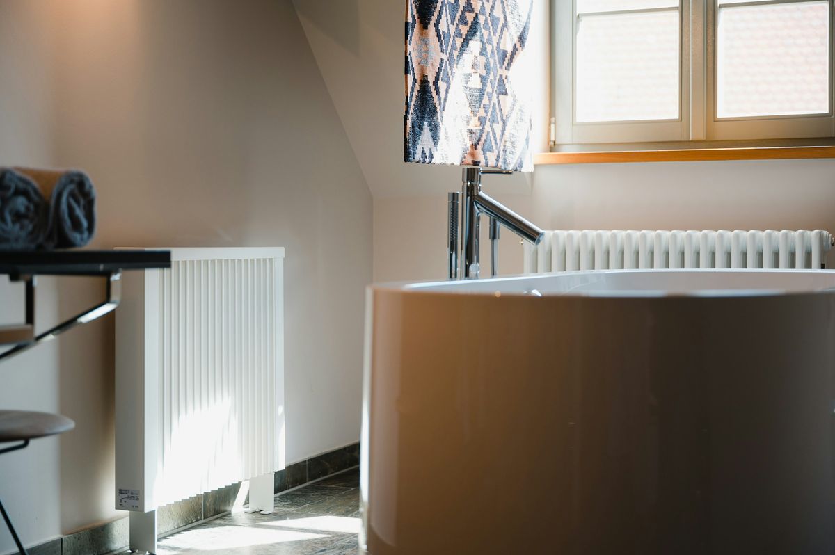 Een badkamer met een bad, een lavabo en een radiator